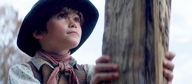 Nico Tirozzi as William Crockett, nervously holding a block of wood for his brother to chop in The Ballad of Davy Crockett (2024)