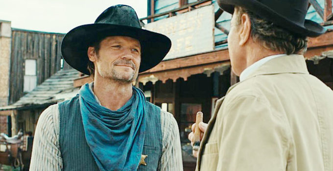 Bailey Chase as Hunter Braddock, getting a lesson in a town's future from Ambrose Masse (Martin Kove) in Far Haven (2023)