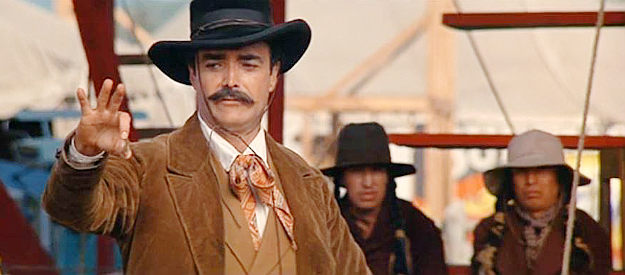 John Considine as Frank Butler, nervously holding a coin for wife Annie Oakley to shoot in Buffalo Bill and the Indians (1976)