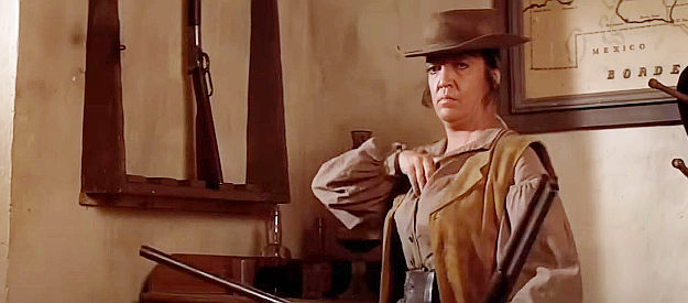 Katy Jurado as Mrs. Baker, tucking extra shotgun shells into her blouse as her husband prepares to go after Billy in Pat Garrett and Billy the Kid (1973)