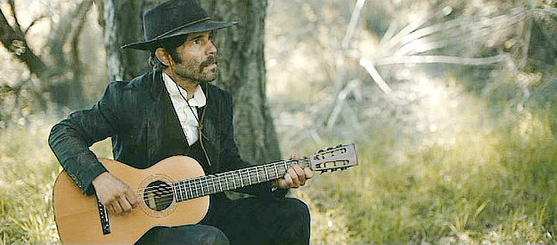 Thom Chacon as Finnegan, another Civil War veteran, singing about being spared during the war in The Outlaws (2023)