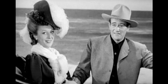 Ann Dvorak as Ann 'Flaxen' Tarry and John Wayne as Duke Fergus, getting acquainted on the San Francisco beach in Flame of the Barbary Coast (1945)