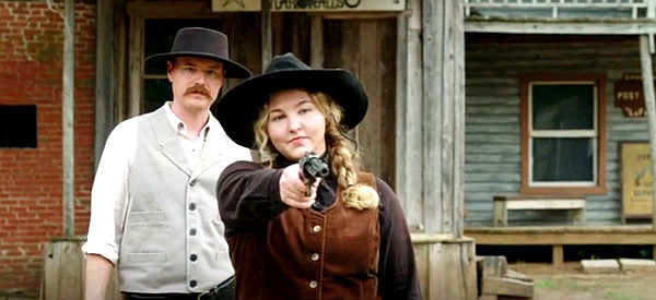 Blaine Hall as Chris Masden and Emma Lord as Cattle Annie during shooting practice in The Guardsmen III (2024)