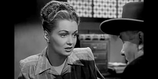 Gloria Henry as stage line owner Jeannie Manning, talking about the recent holdups with mine owner McHugh in Adventures in Silverado (1948)