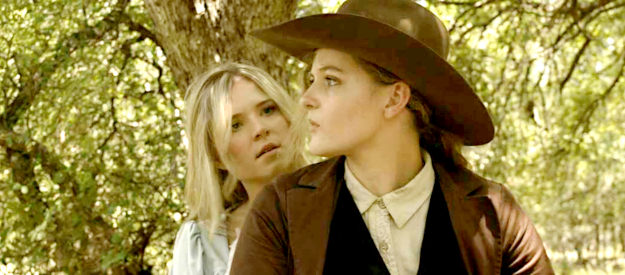 Nicole Mattox as Ellie and Lisa Butala as Dunn, concerned they won't be able to escape riding double in Lady Outlaw (2024)