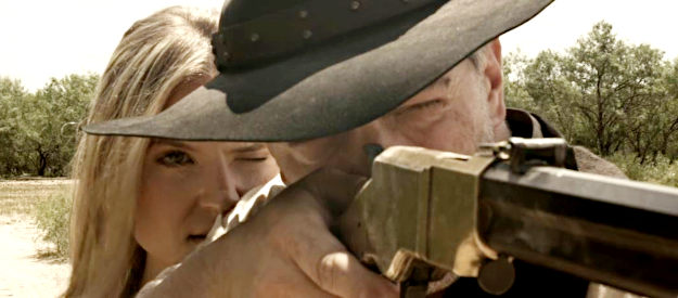 Nicole Mattox as Ellie, helping George (Christopher Henry) sight his rifle in Lady Outlaw (2024)