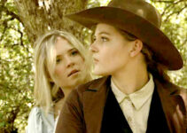 Nicole Mattox as Ellie and Lisa Butala as Dunn, concerned they won't be able to escape riding double in Lady Outlaw (2024)