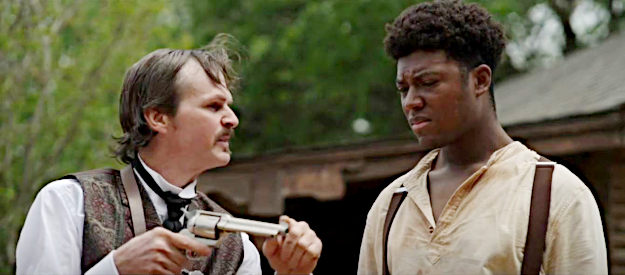 Tom Zembrod as Doc Holliday showing Curtis Griffin (Bobby Ray Thompson III) how to use a six-shooter in Doc Holliday 3 (2024)