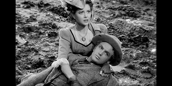 Ann Rutherford as Anne Grayson, fearing Jim Holliday (Robert Stack) has been struck by a stray bullet in Badlands of Dakota (1941)