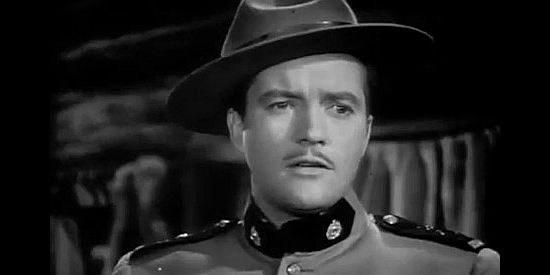 Dennis Morgan as John Keith, posing as a Mountie for the first time in River's End (1940)