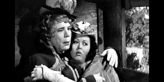 Joe E. Brown as Henrietta Oglethorpe, drawing Elena Conchita Montoya (Adele Mara) close as bandits attack in Shut My Big Mouth (1942)