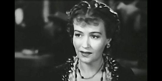 Ona Munson as Julie O'Conover, willing to do most anything to keep younger sister Phyllis out of Tom Cook's arms in Wagons Westward (1940)