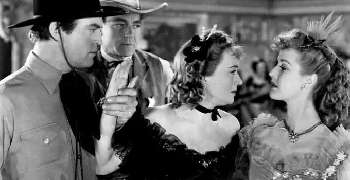 Chester Morris as David Cook and Buck Jones as Jim McDaniels look on as sisters Julie O'Conover (Ona Munson) and Phyllis (Anita Louise) spat in Wagons Westward (1940)