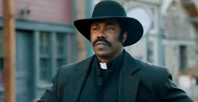 Michael Jai White as Johnny Black, ready to defend the residents of Hope Springs with Bible or six-guns in Outlaw Johnny Black (2023)