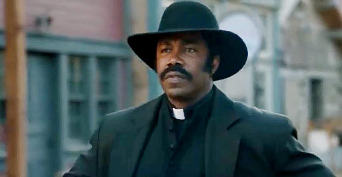 Michael Jai White as Johnny Black, ready to defend the residents of Hope Springs with Bible or six-guns in Outlaw Johnny Black (2023)