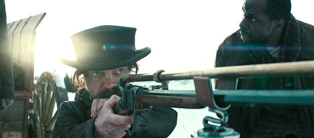 Peter Dinklage as Reginald Jones, taking aim at a pursuing posse with his long-range rifle in The Thicket (2024)