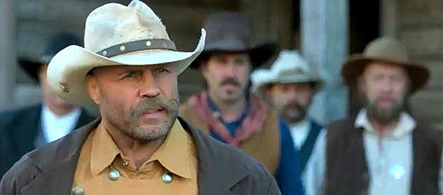 Randy Couture as Bill Bassett, one of the lawmen on the trail of Johnny Black in Outlaw Johnny Black (2023)