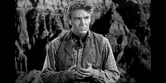 Robert Stack as Jim Halliday, finding an incriminating piece of evidence against his brother in Badlands of Dakota (1941)