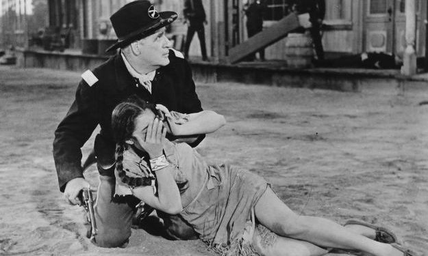 Rusty Lane as the Captain, trying to save Keetah after she's dumped in the street during an Indian raid in The Rawhide Trail (1958)