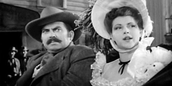 Thomas Gomez as Ballard and Diana Barrymore as Claire, reacting to Steve Logan rambunctious arrival in Abilene in Frontier Badmen (1943)