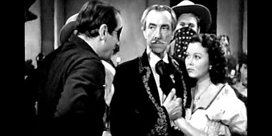 Victor Jory as Buckskin Bill, demanding a $50,000 ransom from Don Carlos Montoya (Pedro de Cordoba) and daughter Elena (Adele Mara) in Shut My Big Mouth (1942)