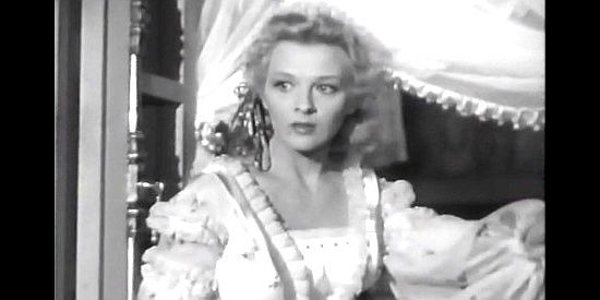 Ilona Massey as Natalia Alanova, watching for a particular person as convicts march past her window in Northwest Outpost (1947)