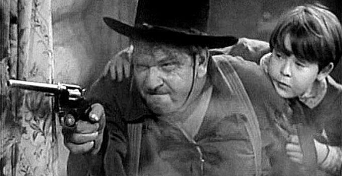 Wallace Beery as Reb Harkness, ready to send a Sioux warrior to his happy hunting ground as Jimmy Kincaid (Bobs Watson) looks on in Wyoming (1940)