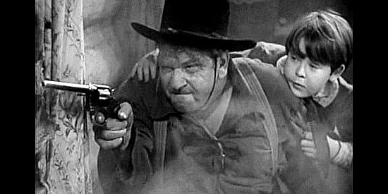 Wallace Beery as Reb Harkness, ready to send a Sioux warrior to his happy hunting ground as Jimmy Kincaid (Bobs Watson) looks on in Wyoming (1940)