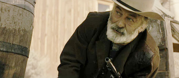 Alec Baldwin as Harland Rust, looking for cover during a shootout in Rust (2024)