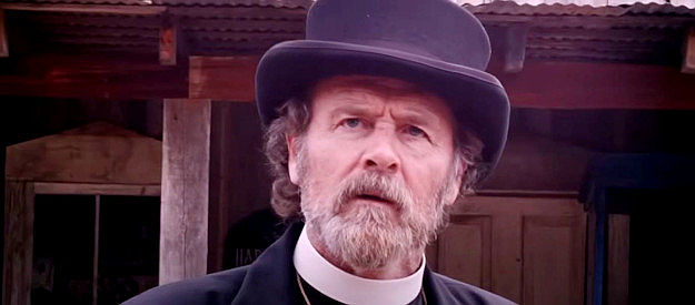 J.F. Davis as The Rev. Silas Parker, trying to stand up to Nate Jones and his gang in Showdown on the Brazos (2025)