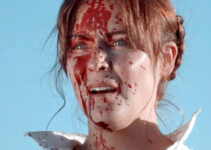 Sheri Rippel as Molly Pray, splattered in her husband's blood after a bounty hunter's visit in They Call Her Death (2025)