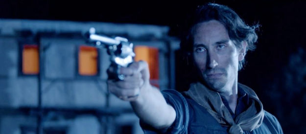 Tyler Boettcher as Billy, drawing a bead on a friend fleeing with a satchel full of loot in Blood in Them Hills (2025)