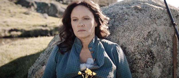 Leah Purcell as Molly Johnson, enjoying a quiet moment in the hills, gun near her side, before going into childbirth in The Legend of Molly Johnson (2021)
