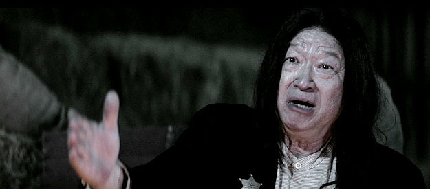 Tzi Ma as Lin, explaining how he became a wanted man by avenging a family member in Gunslingers (2025)