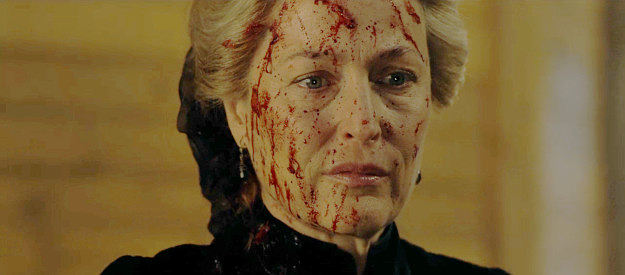 Gillian Anderson as Constance Van Ness, wearing the blood from a massacre she helped provoke in The Abandons (2025)