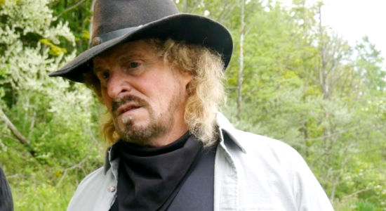 Ken Van Sant as Carson Weaver, coming across an outlaw's campsite and finding sings of a struggle in Once Upon a Time in Amityville (2024)