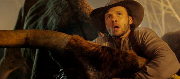 Nick Robinson as Elias Teller, trying to calm a spooked bull about to fall off a ledge in The Abandons (2025)