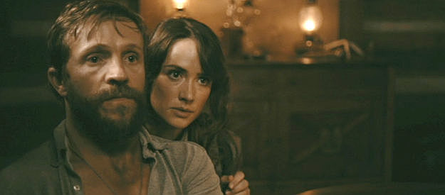 Creed Garnick as Harry Longbaugh and Alexandra Harris as Etta Place, concerned about a knock on the door in Cottonmouth (2025)