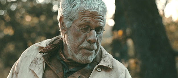 Ron Perlman as Victor Cain, encouraging Ed Dante to eat his food in Cottonmouth (2025)