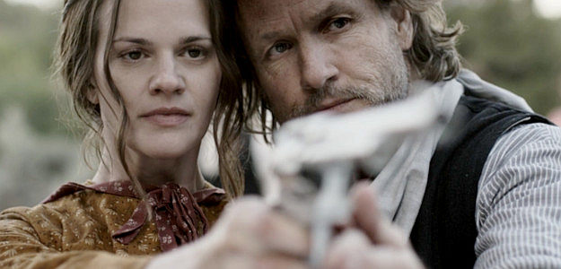 Maggie Gwin as Lillith Ballard gets shooting lessons from Ned Campbell (Martin Dingle Wall) in This Bloody Country (2025)