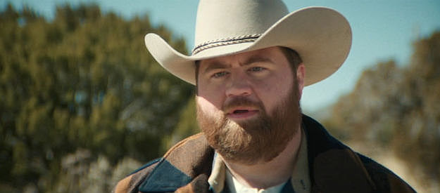 Paul Walter Hauser as Lefty Ledbetter, setting out to complete the quest for Penny Jo's benefit in Americana (2023)
