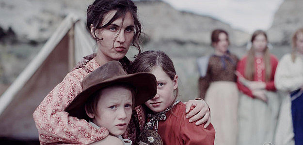 Rainey Qualley as Abigail Ballard, protecting her children Charity (Georgia Coles) and Hope (Brookelyn Lindley) in This Bloody Country (2025)