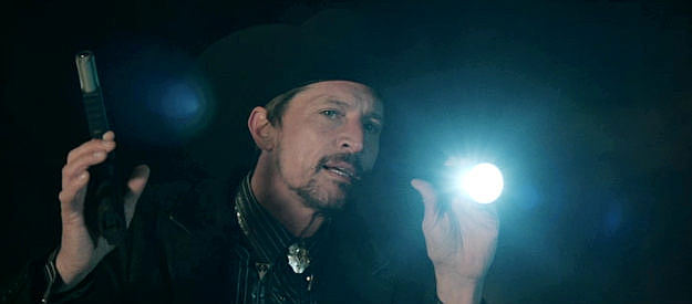 Simon Rex as Roy Lee Dean, arriving at the Starr family compound to deal for the ghost shirt in Americana (2023)