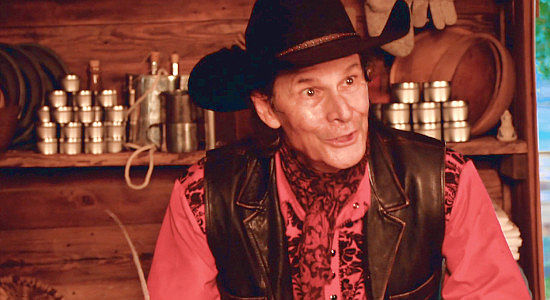 Christopher Corson as Curly Belle, the businessman who refuses to pay Sam a fair price for his crops in Reina of the West (2022)