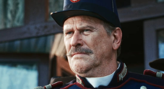 Mirko Artuso as Ercole Rupe, watching a competition that's supposed to be fixed in his favor in Heads or Tails (2025)