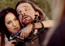 Celeste Luccitti as Bessie, holding a gun on a bounty hunter named Wallace (Christopher Beeman) in Blood Totem (2026)