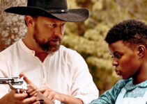 Don Jeanes as Sam giving teenage Reina (Ellen Harris) six-gun lessons in Reina of the West (2022)