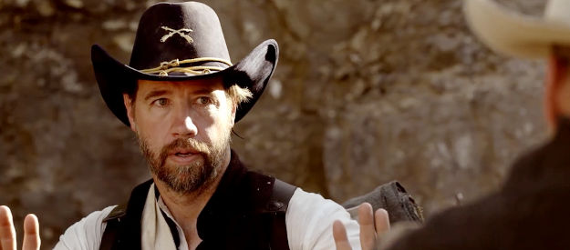 Tim Sauer as Capt. Rhodes, held at gunpoint by a man who should be dead in Blood Totem (2026)