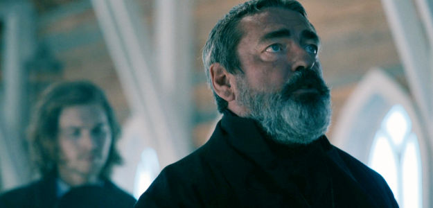 Angus MacFayden as The Rev. Elias Fremont, praying with 'Jo' Beckett after her son goes missing in The Wolf and the Lamb (2026)