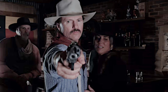 Matt Malone as Colt Williams, protecting Angel (Michelle Malone) from ruffians in the saloon in Denison in The Whore and the Horseman (2025)